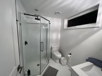 a white bathroom with a shower and a toilet at 2 Bed Town ideal for a fun-filled family vacation in Niagara Falls