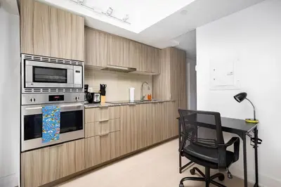 a kitchen with a desk and a chair in a room at Modern Micro Studio in Heart of Downtown in Toronto