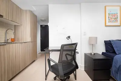 a bedroom with a desk and a bed and a chair at Modern Micro Studio in Heart of Downtown in Toronto