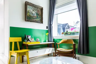 a green room with two chairs and a desk and a window at Drake Devonshire and Motor Inn in Wellington