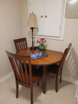 a wooden table with two chairs and a lamp on it at Cozy and comfy Studio Apartment in Richmond Hill