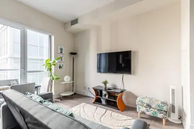a living room with a couch and a flat screen tv at Modern Suite w City Views - Downtown in Toronto
