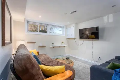 a living room with a couch and a tv at Bright & Modern 1 bedroom unit! in Guelph