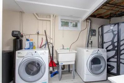 a laundry room with two washing machines and a sink at Bright & Modern 1 bedroom unit! in Guelph