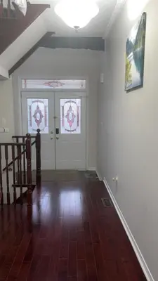 an empty room with a staircase and two stained glass windows at Near Toronto Pearson Airport Queen Room in Brampton
