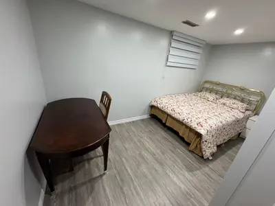 a bedroom with a bed and a table and a desk at 1 bedroom cozy apartment in Kitchener