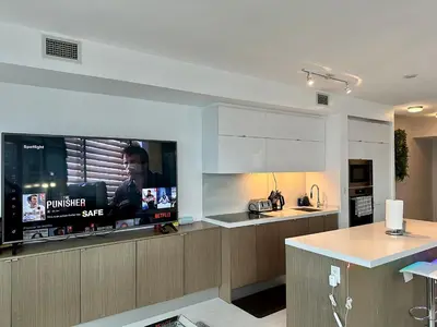 a kitchen with a flat screen tv and a counter at Cityview in the Sky 2Bdrms 2Baths 5realbeds in Toronto