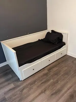 a bed with white drawers and a black mattress at Quaint and Cozy Haven in Toronto