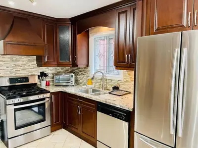 a kitchen with wooden cabinets and a stainless steel refrigerator at Three bedroom house in Mississauga