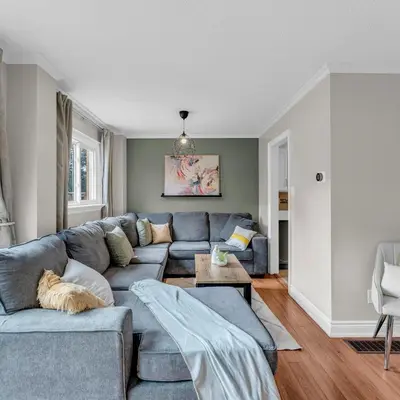 a living room with a blue couch and a table at Retro Arcade & Gaming Home by Pako Stays in Brampton