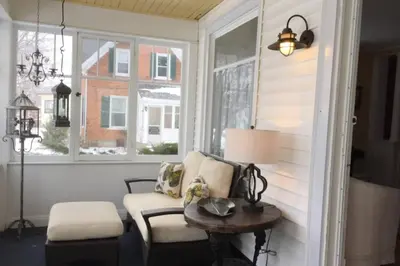 a room with a chair and a table and windows at Gwyn Haven - Spacious Charming Century Home in Wellington in Wellington