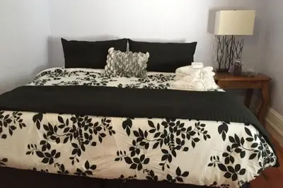 a bed with a black and white comforter on it at Gwyn Haven - Spacious Charming Century Home in Wellington in Wellington