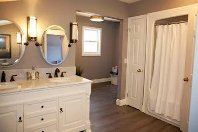 a bathroom with two sinks and a mirror at Gwyn Haven - Spacious Charming Century Home in Wellington in Wellington