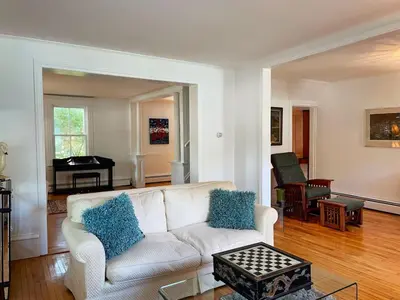 a living room with a white couch and a piano at Gwyn Haven - Spacious Charming Century Home in Wellington in Wellington