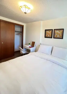 a bedroom with a large white bed and a desk at Entire Cozy House in Thorold in Thorold