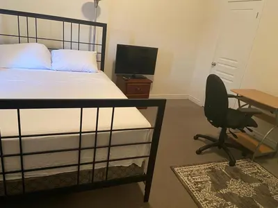 a bedroom with a bed and a desk and a chair at Divinity Hut in Brampton