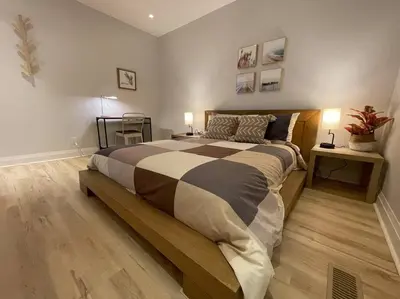 a bedroom with a large bed with two tables and two lamps at Stylish 3-bdrm suite w free Parking in Kitchener