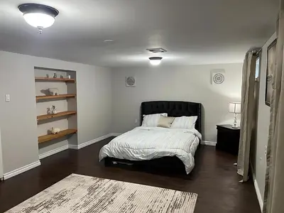 a bedroom with a bed with a black headboard at Home by Dolly in Toronto