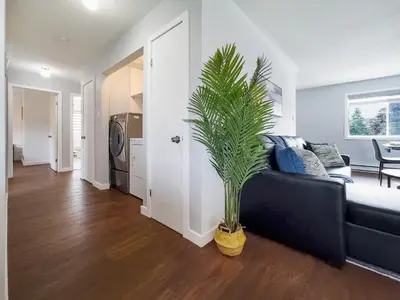 a living room with a couch and a palm tree at Pet-Friendly Large 3-Bedroom - Bobcaygeon in Bobcaygeon
