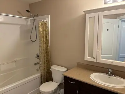 a bathroom with a toilet and a sink and a shower at Room in neat comfy house in Kitchener