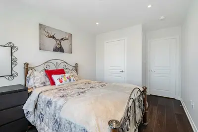 a bedroom with a bed and a painting on the wall at Meadowcrest Semi in Mississauga