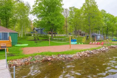 a playground next to a body of water at LUX Lakefront Sleeps18 Pickleball HotTub Sauna Gym Arcade Basketball Volleyball in Buckhorn