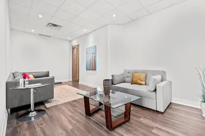 a living room with two couches and a table at Finch West Residence Suites - Hotel DUKE in Toronto