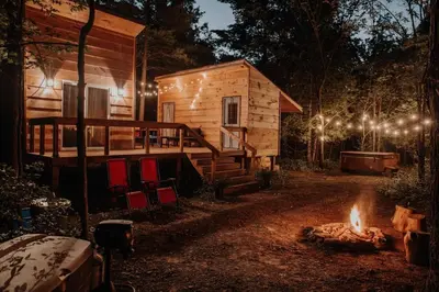 a log cabin with a fire in front of it at The Green Acres Cabin in Hamilton