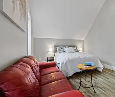 a living room with a couch and a bed at ENTIRE BACHELOR UNIT EN-SUITE ACROSS FROM GOOGLE - br4 in Kitchener