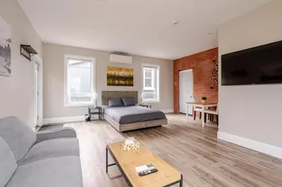 a living room with a bed and a table at ENTIRE BACHELOR UNIT EN-SUITE ACROSS FROM GOOGLE - br3 in Kitchener