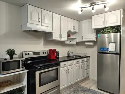 a kitchen with white cabinets and stainless steel appliances at Basement Waterloo Near 24-7 Restraints in Waterloo
