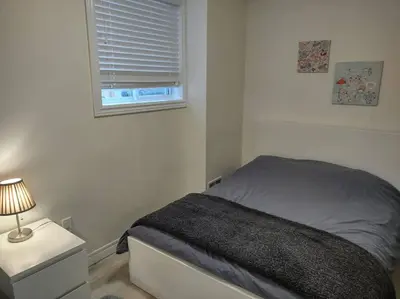 a small bedroom with a bed and a window at Basement Waterloo Near 24-7 Restraints in Waterloo
