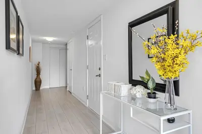 a hallway with a console table with yellow flowers on it at Posh 4 Bed Home with Backyard in Great Location in Burlington