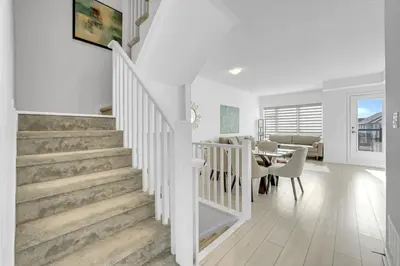 a white staircase in a living room with a dining room at Posh 4 Bed Home with Backyard in Great Location in Burlington