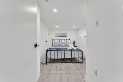 a bedroom with a bed in a white room at Luxury Comfort 3 BR Near Hospitals Tims Field GO in Hamilton