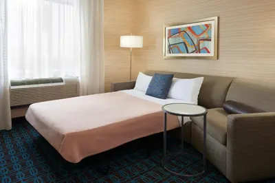 a hotel room with a bed and a couch at Fairfield Inn & Suites by Marriott Barrie in Barrie