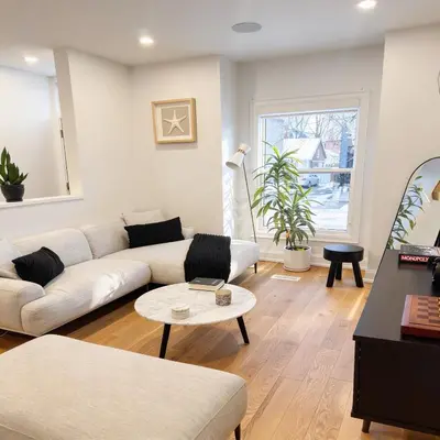 a living room with a couch and a table at Beautiful modern 2Bdr sunny home with French decor in Hamilton