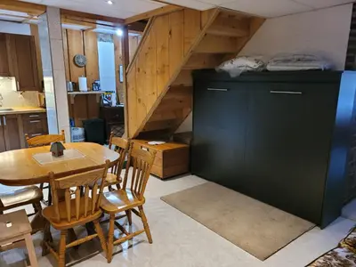a kitchen and dining room with a table and a staircase at Bowering Lodge in Blue Mountains