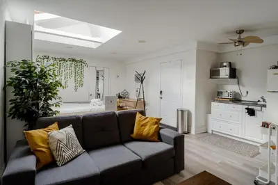 a living room with a couch and a bedroom at West House Private Garden Suite with Skylight in Brampton