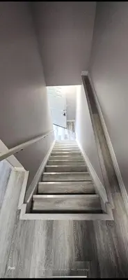 a staircase leading up to a room with white walls at Affordable Basment Apartment - London in London