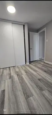 an empty room with doors and a wooden floor at Affordable Basment Apartment - London in London