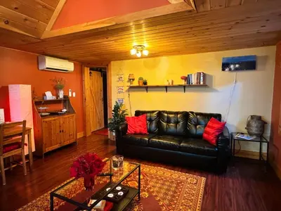 a living room with a leather couch and a table at The Cozy Corner in Elora