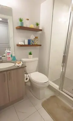 a bathroom with a shower and a toilet and a sink at Lakeview Escape Endy KING BED in Pickering