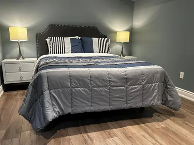 a bedroom with a large bed with two lamps at Fully Furnished Guest Suite in Richmond Hill