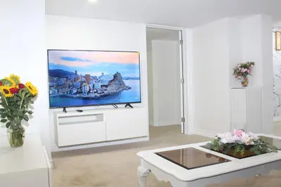 a living room with a flat screen tv on a wall at Exclusive Private Basement in London