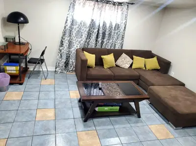 a living room with a brown couch and a coffee table at Home away from home in Brampton