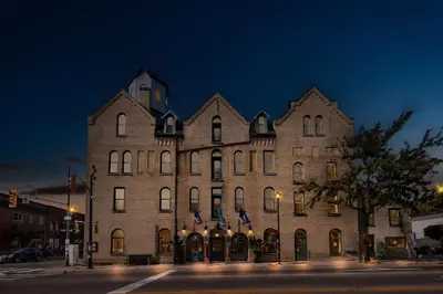 a large brick building on a city street at night at The Arlington Hotel - BW Signature Collection in Paris
