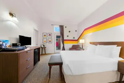 a hotel room with a white bed and a colorful stripe at The Arlington Hotel - BW Signature Collection in Paris