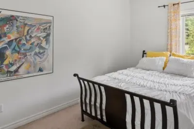 a bedroom with a bed and a painting on the wall at Summer Getaway with Pool and Nearby Attractions in Cobourg