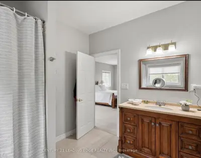 a bathroom with a sink and a mirror at Summer Getaway with Pool and Nearby Attractions in Cobourg